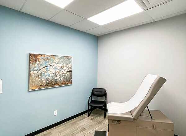 A photo of a beautiful room with a wooden-tiled floor and artwork on the wall used for patient care at Swift Health Morrow