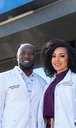 Two Swift Health Morrow doctors standing together in front of the clinic's front door