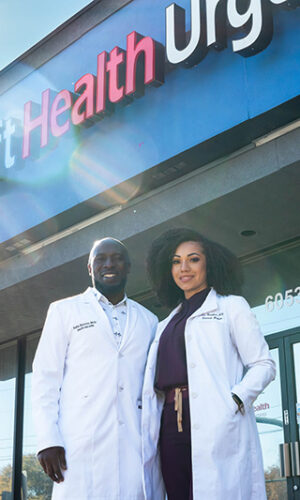 Two doctors at Swift Health Morrow smiling together in front of the clinic