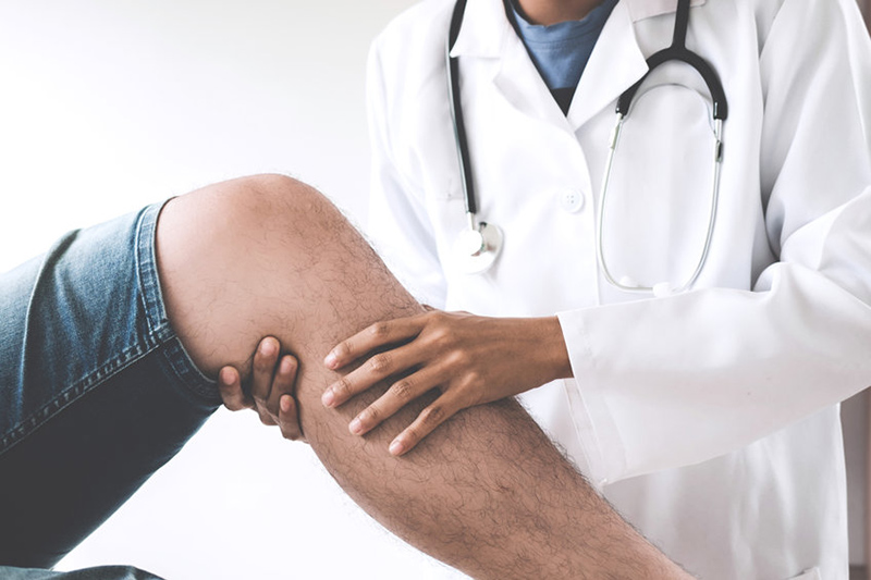 A patient with knee pain being examined by a doctor
